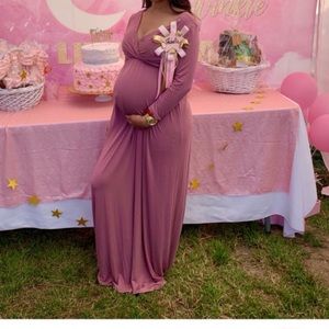 A long beautiful maternity dress with sleeves .